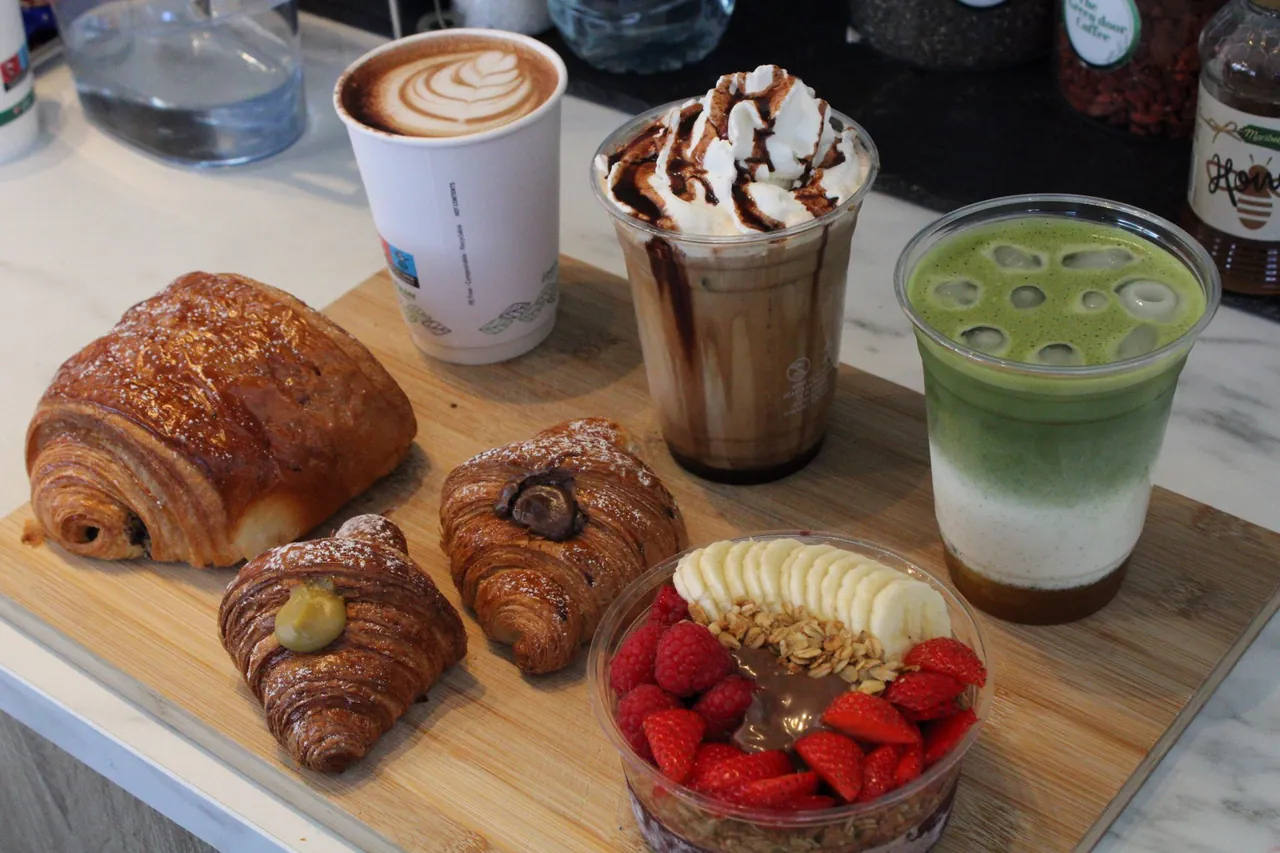 Coffee, iced mocha, matcha and pastries on a board