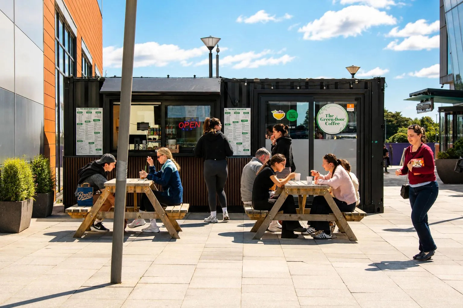The Green Door Coffee truck with customers at picnic tables on a sunny day